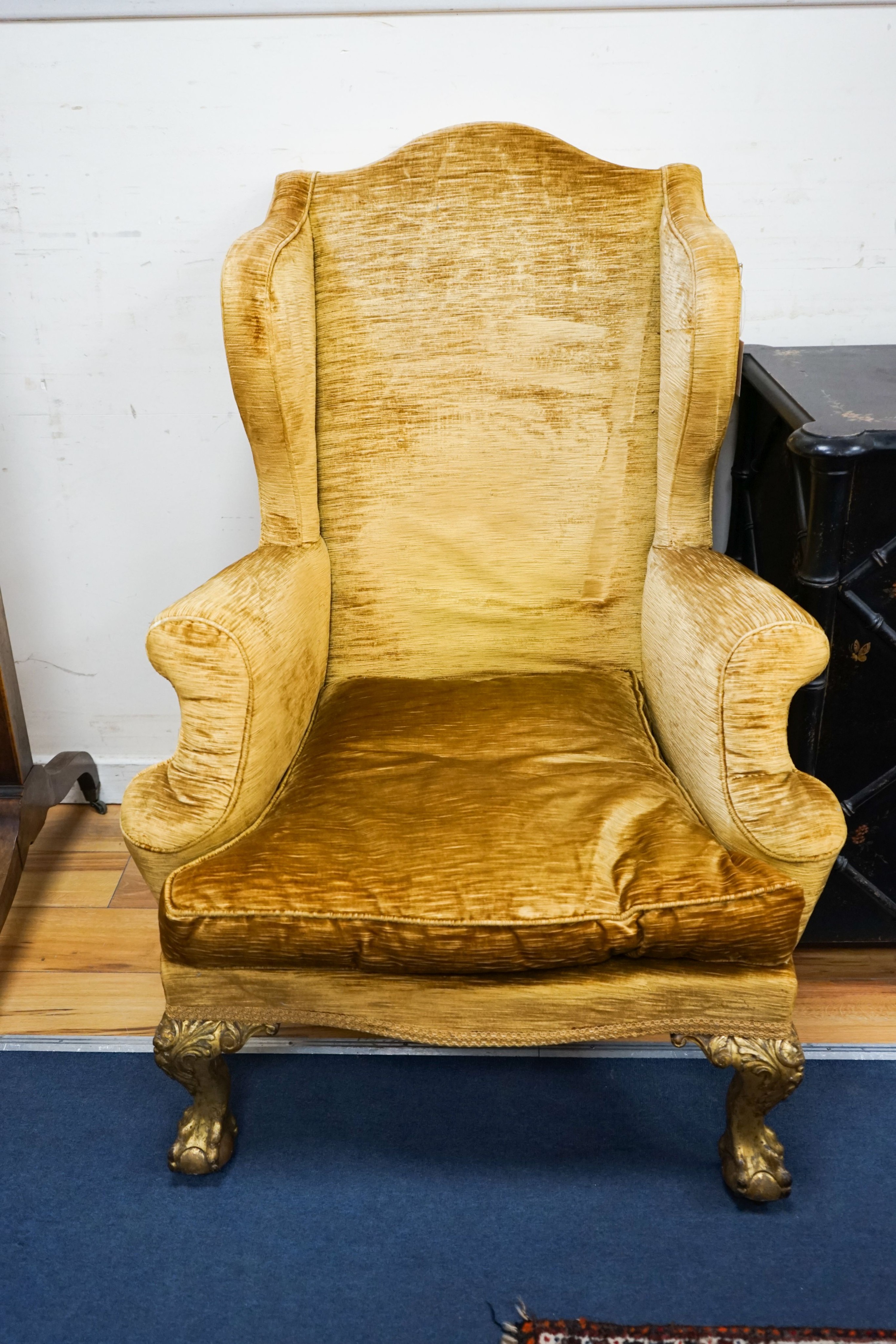 A Chippendale style gold velvet wing backed chair